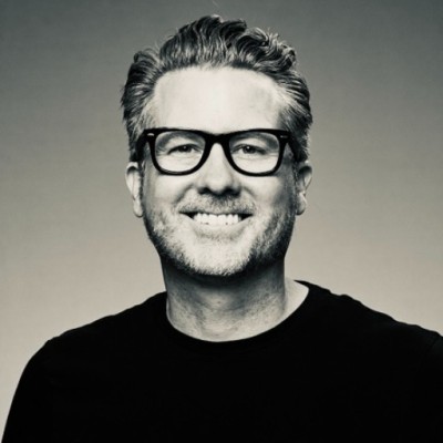 Patrick Kennedy smiling, wearing glasses and a black shirt
